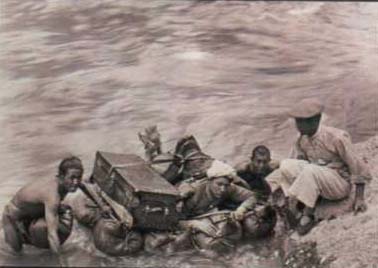  Люди, нанятые Роком для экспедиции, переправляют багаж исследователя через реку Янцзы.